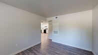 Located at 2593 Millcreek Dr in Sacramento, California, this single-floor, 2-bedroom, 2-bathroom home offers a clean and functional layout with modern updates throughout. The kitchen is a standout feature, showcasing crisp white shaker-style cabinetry extending to the ceiling, white countertops, and black stainless appliances including a refrigerator, electric range, and dishwasher. Light wood-style flooring in the kitchen flows into the adjacent living area, which is equipped with a ceiling fan and an open feel. Rich, dark wood-style vinyl flooring runs through the bedrooms and remaining living spaces, complementing the neutral gray walls and white trim. The primary bedroom offers a comfortable footprint with a windowed view to the outdoors and a closet with classic six-panel doors. The second bedroom is similarly appointed with natural light and the same consistent flooring. Both bathrooms feature tub-shower combinations with brushed nickel fixtures — one includes a wall-mounted sink with a vanity mirror, while the other offers a more enclosed layout. Throughout the home, the design is cohesive, clean, and move-in ready, reflecting a straightforward, well-maintained residential space in Sacramento's Millcreek neighborhood.
