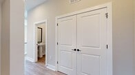 This 840 square foot single-floor residence offers a thoughtful layout that maximizes space and functionality. The home features one bedroom, measuring a generous 210 square feet, and two full bathrooms, providing ample convenience for residents and guests alike. The heart of the home is an open-concept kitchen and living room area, designed to create a seamless flow for daily living and entertaining.

Light wood-toned vinyl flooring runs throughout the space, complementing the neutral off-white walls and adding warmth to the interior. The room benefits from recessed lighting and a modern ceiling fan, ensuring both ambiance and comfort. Large windows, including a transom window above what appears to be a patio door, flood the space with natural light, enhancing the sense of openness.

The visible doorway leads to one of the bathrooms, featuring crisp white finishes that align with the home's contemporary aesthetic. A closet provides additional storage, crucial in a compact living space. The clean lines and minimalist design approach create a canvas for personalization while maintaining a fresh, modern appeal. This efficient layout demonstrates how thoughtful design can make a smaller space feel expansive and inviting.