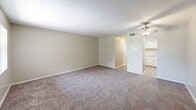 Located at 2050 S Ridgewood Ave in South Daytona, Florida, this one-bedroom, one-bathroom unit offers a practical and comfortable single-floor layout. The open living area features neutral-toned walls, soft wall-to-wall carpeting, and a ceiling fan with a light fixture, creating a relaxed and functional space. The kitchen is efficiently designed with white cabinetry, light countertops, wood-look vinyl flooring, and black appliances including an electric range and full-size refrigerator, along with a double-basin stainless steel sink. The spacious bedroom is carpeted and includes a window that allows natural light to filter in, complemented by a ceiling fan overhead. A standout feature of the bedroom is its generous dual closet storage, with two sets of louvered bi-fold doors providing ample organization space. The bathroom is clean and straightforward, featuring a tub-shower combination with a white surround, a vanity with a light countertop, and wood-look flooring. Throughout the unit, the consistent use of neutral tones and practical finishes creates a cohesive and move-in-ready ambiance well-suited for comfortable everyday living.