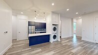 Located at 715 Park Ave in East Orange, NJ, this thoughtfully designed 2-bedroom, 2-bathroom unit offers a modern living experience with high-quality finishes throughout. The open-concept kitchen is a standout feature, showcasing bold navy blue cabinetry that extends to the ceiling, a striking blue tile backsplash, stainless steel appliances including a refrigerator, gas range, and built-in microwave, and a white quartz peninsula illuminated by sleek pendant lights. A stacked in-unit washer and dryer is conveniently integrated into the living area. Light gray wood-look flooring flows seamlessly throughout, complementing the crisp white walls and recessed lighting that keep the space bright and airy. The primary bedroom is generously proportioned, featuring large windows with views of the surrounding greenery, a walk-in closet, and a wall-mounted split A/C unit. The second bedroom is equally well-lit with natural light streaming through its window. Both bathrooms are finished with large-format gray stone-look floor and shower tiles paired with classic white subway wall tiles, a soaking tub, and contemporary vanities, creating a clean, spa-like aesthetic.