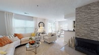 Located at 1941 Hidden Lake Drive in Stow, Ohio, this single-floor 2-bedroom, 2-bathroom residence combines comfortable living with modern, stylish finishes. The open-concept living and dining area is bright and welcoming, featuring large windows with blinds that fill the space with natural light, plush carpeting, and a textured ceiling. A tile-accented fireplace serves as a focal point, adding character to the main living area. The kitchen is outfitted with dark cabinetry, dark countertops, and stainless steel appliances, including a range and microwave. It connects conveniently to a dedicated laundry area with wood-look vinyl flooring that extends through the kitchen and utility spaces. The dining area sits adjacent to the kitchen, offering a seamless flow for everyday living and entertaining. Both bedrooms are generously sized with soft carpeting, ample natural light from well-positioned windows, and room for full bedroom furniture sets. Each bathroom features rich dark wood vanities with white countertops and wood-look vinyl flooring. The primary bathroom includes a glass-enclosed shower, while the second bathroom offers a tub-shower combination. The overall design is cohesive, with a neutral palette that creates a clean and inviting atmosphere throughout.