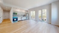 Located at 229 Willett Ave in Port Chester, NY, this thoughtfully designed residence offers three bedrooms and three full bathrooms across a single, well-organized floor. Light-toned hardwood flooring flows throughout, creating a clean, cohesive aesthetic that enhances the bright, airy atmosphere found in every room.

The open-concept living and kitchen area serves as the heart of the home, featuring floor-to-ceiling glass doors that open to a private balcony with views of surrounding greenery. The kitchen is equipped with stainless steel appliances, white cabinetry with a tile backsplash, and ample counter space, seamlessly connecting to the expansive living area bathed in natural light.

Each bedroom is generously proportioned, with crisp white walls, recessed lighting, and windows that invite natural light and outdoor views. The primary bedroom offers a comfortable, well-sized retreat. All three bathrooms are finished with large-format light stone-effect tiles, modern white vanities with under-mount sinks, backlit mirrors, and matte black hardware and fixtures, lending a refined, contemporary feel.

The hallway connects all spaces efficiently, and the overall layout maximizes functionality. Recessed lighting throughout complements the natural light, making the entire residence feel open, modern, and move-in ready.