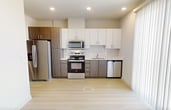 This 510-square-foot, one-bedroom, one-bathroom apartment located at 707 W Slaughter Lane in Austin, Texas offers a thoughtfully designed single-floor layout. Light wood-style flooring flows consistently throughout the unit, creating a clean and cohesive aesthetic.

The kitchen is a standout feature, equipped with a full suite of stainless steel appliances including a refrigerator with ice maker, electric range, over-the-range microwave, and dishwasher. Two-tone cabinetry pairs dark wood lower cabinets with white upper cabinets, complemented by white countertops and a tile backsplash, maximizing both style and storage.

The bedroom spans 110 square feet and includes a ceiling fan and direct access to a dedicated closet with built-in shelving, providing practical storage solutions. The bathroom features a full tub-shower combination, a wood-toned vanity with overhead cabinetry, and a clean white finish throughout.

Neutral wall tones and recessed lighting throughout the unit contribute to a bright, modern ambiance. Vertical blinds in the living area allow for adjustable natural light. The efficient floor plan makes excellent use of the available space, making this unit well-suited for individuals or couples seeking a contemporary apartment in South Austin.