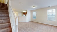 Located on E Park Ave in Savannah, Georgia, this two-story home offers a practical and well-organized layout spread across two levels. The main level centers around an open kitchen equipped with warm honey-toned wood cabinetry, light countertops, wood-look vinyl flooring, and white appliances including a range, dishwasher, and refrigerator. A peninsula counter connects the kitchen to the adjacent living area, which features neutral carpet and a window that brings in natural light. A staircase with a classic white balustrade leads to the upper level.

Upstairs, multiple carpeted rooms provide versatile living spaces. Each room benefits from natural light via single or paired windows fitted with blinds. One room features an elegant chandelier, adding a refined touch. The upper level also includes two full bathrooms, each outfitted with a tub/shower combination, wood-look vinyl flooring, and warm wood vanity cabinetry with light countertops. Throughout the home, a consistent neutral color palette of soft beige tones creates a clean and cohesive aesthetic, while the multi-room layout across two floors offers flexibility for a variety of living arrangements.