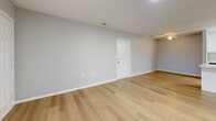 Located at 1400 Fuller Ct in Lancaster, Ohio, this well-appointed 2-bedroom, 3-bathroom single-story home offers a clean, modern aesthetic throughout. Light wood-look luxury vinyl flooring runs seamlessly across the main living areas, complemented by neutral gray walls and crisp white trim that create a bright, cohesive feel.

The open-concept kitchen is a standout feature, boasting white shaker-style cabinetry, sleek marble-look countertops, stainless steel appliances including a refrigerator, dishwasher, microwave, and electric range, all set against the same warm flooring found throughout the home. The adjoining living area provides a generous, open layout ideal for everyday living.

The spacious primary bedroom features a ceiling fan, a window allowing natural light, and direct access to a walk-in closet with wire shelving. Its en-suite bathroom includes a white vanity with an illuminated mirror, a walk-in glass-door shower, and built-in open shelving. The second bedroom is equally well-sized with its own ceiling fan and closet access.

Additional highlights include a utility closet with electrical panel access and wire shelving, and an unfinished basement offering substantial storage or expansion potential. The home's clean, updated design makes it a functional and attractive residence in Lancaster, OH.