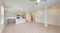Located at 540 Hobbs Road in League City, Texas, this well-appointed single-story home offers a thoughtfully designed open layout that maximizes its generous floor area. Light-toned hardwood-style flooring, crisp crown molding, and neutral warm walls create a clean, cohesive aesthetic throughout.

The kitchen is a standout feature, showcasing gray shaker-style cabinetry with brushed gold hardware, white quartz countertops, a classic subway tile backsplash, and a full suite of stainless steel appliances including a refrigerator, range, microwave, and dishwasher. A large central island with pendant lighting above serves as both a prep space and a gathering point, seamlessly connecting the kitchen to the living area. The living room benefits from natural light streaming through windows with exterior views, and is complemented by a ceiling fan with a gold-toned fixture.

The spacious primary bedroom offers a ceiling fan, natural light from multiple windows, and direct access to the bathroom. The bathroom features an extended dual-sink vanity with white quartz counters, a glass-enclosed shower, and light wood-style flooring. Two closets provide ample storage, including a walk-in with built-in shelving and hanging rods. The attached garage completes this well-rounded home.