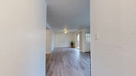 This single-floor, 2-bedroom, 2-bathroom home offers a thoughtfully designed layout that maximizes comfort and functionality. The open living room is a standout space, featuring light-toned laminate hardwood flooring, a textured ceiling, a ceiling fan, and a classic brick fireplace that serves as a focal point. A sliding glass door floods the room with natural light and provides direct access to an outdoor area, while an additional window ensures the space remains bright and airy.

The kitchen is efficiently laid out with white cabinetry, light countertops, and black appliances, including a range and refrigerator. Hardwood-style flooring continues throughout, giving the kitchen a clean and cohesive look.

Both bedrooms offer plush carpeting for added comfort, with crisp white walls and ample closet space — including walk-in style closets with built-in shelving for convenient storage. The primary bedroom provides a generous footprint well-suited for a full furniture arrangement.

The two bathrooms are clean and simply appointed, each featuring light hardwood-style flooring, vanity countertops, and bright white finishes throughout. With three total closets spread across the floor plan, this home provides abundant storage to complement its well-organized and functional living spaces.