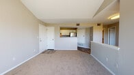 Located at 10571 Colorado Blvd in Thornton, Colorado, this single-floor residence offers a well-designed layout with a blend of comfort and functionality. The living area is a standout feature, boasting soaring vaulted ceilings that create an airy, open atmosphere, complemented by a tile-surround fireplace and large windows that fill the space with abundant natural light and views of surrounding greenery. Soft carpeting extends throughout the living and bedroom areas, adding warmth underfoot.

The kitchen is designed in a galley style with white cabinetry, grey laminate countertops, and a full suite of stainless steel appliances, including a refrigerator, range, and dishwasher. Wood-look flooring runs through the kitchen, providing a clean contrast to the carpeted areas. A pass-through opening connects the kitchen visually to the main living space, enhancing the open-concept feel.

The bedrooms are generously sized with vaulted ceilings and large sliding windows that bring in natural light and outdoor views. The bathroom features white cabinetry, a wide vanity with a single sink, granite-style countertops, a large mirror, and wood-look flooring. Clean, neutral tones throughout the residence create a cohesive and inviting ambiance.