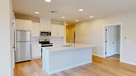 This well-designed single-story home offers a thoughtful layout across three bedrooms, two bathrooms, and a generous living area. The open-concept kitchen serves as the heart of the home, featuring crisp white shaker cabinets, a subway tile backsplash, stainless steel appliances, and a large central island with an undermount sink — ideal for both cooking and casual dining. Light-toned hardwood flooring flows consistently throughout, lending warmth and continuity to every room.

The spacious primary bedroom provides a comfortable retreat, accompanied by a walk-in closet outfitted with wire shelving for organized storage. The two bathrooms are finished in a clean, contemporary style, with the primary bath showcasing a dual-sink vanity with white quartz countertops, brushed nickel hardware, and light tile flooring. The additional bedrooms are bright and airy, each featuring large windows that invite natural light and outdoor views of the surrounding greenery.

A dedicated laundry room includes a full-size washer and dryer with overhead wire shelving for added utility. Recessed lighting throughout the home and a neutral color palette create a bright, modern ambiance. The single-floor layout ensures easy accessibility, making this a highly functional and inviting living space.