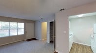 Located at 2310 W Cameo Ln in Knightdale, NC, this single-story home offers a functional and straightforward layout designed for comfortable everyday living. The living area greets you at the entry with soft wall-to-wall carpeting, a front-facing window that draws in natural light, and a conveniently positioned built-in shelving closet for additional storage. The space transitions seamlessly into the kitchen, which features white cabinetry, laminate countertops, a coil-burner electric range, and a full-size refrigerator — all finished in a clean, neutral palette. Hardwood-style flooring anchors the kitchen area, providing a pleasant contrast to the carpeted living spaces. The bedrooms are generously sized with plush carpeting, neutral-toned walls, and windows that allow for natural light throughout. A textured ceiling is consistent across the home, adding subtle architectural character. The bathroom is well-appointed with tile flooring, a full-size soaking tub with a shower/tub combo, a vanity, and clean white finishes. Throughout the home, the neutral color scheme and clean lines create a calm, move-in-ready environment well-suited for a variety of lifestyles.