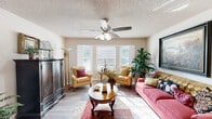 Located at 3200 Stone Rd SW in Atlanta, GA, this single-story residence offers three bedrooms and three full bathrooms within a well-organized floor plan. The interior is unified by wood-look laminate flooring and neutral-toned walls, creating a clean and cohesive aesthetic throughout.

The living room serves as the heart of the home, anchored by a large bay window that fills the space with natural light. A ceiling fan adds both function and comfort to this welcoming area. Adjacent to it, the dining area features a pendant light fixture and easy access to the front entry, which is finished with a classic six-panel white door.

The kitchen is well-appointed with warm wood-toned cabinetry, ample counter space, a double basin sink, and black appliances including a range and refrigerator. A skylight-style overhead fixture brightens the workspace. The kitchen flows naturally into the dining area, supporting everyday living and entertaining.

The primary bedroom offers a generous footprint with a dedicated walk-in closet featuring built-in shelving rods. Each of the three bathrooms includes a tiled tub-shower combination. Textured ceilings are present throughout, adding a layer of traditional character. The overall layout is efficient and functional, making practical use of every square foot in this Atlanta home.