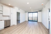 This thoughtfully designed two-bedroom, three-bathroom unit offers a clean, contemporary aesthetic throughout its single-floor layout. Light hardwood flooring flows continuously through every room, lending a cohesive and airy feel to the entire space.

The open-concept living area connects directly to the kitchen, which is well-appointed with white shaker cabinetry, a white subway tile backsplash, light countertops, and a full suite of stainless steel appliances including a refrigerator, electric range, over-the-range microwave, and dishwasher. Recessed lighting and a gold-toned faucet add refined detail to the kitchen.

The living area features exposed ductwork as an industrial design accent and opens onto a private balcony through large black-framed sliding glass doors, offering open outdoor views of surrounding treetops.

Both bedrooms are bright and well-proportioned, each featuring large black-framed grid windows that frame expansive outdoor views and fill the rooms with natural light. Ceiling fans are installed in the bedrooms for added comfort.

The bathrooms maintain the unit's clean palette with white cabinetry, light countertops, and matte black hardware and fixtures. A walk-in closet with a rod provides additional storage. The overall ambiance is modern, bright, and move-in ready.