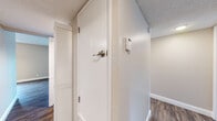 Located at 40495 Chapel Way in Fremont, CA, this single-story residence offers a well-organized layout with a cohesive, updated aesthetic throughout. The entryway features dark hardwood-style flooring that extends through the main living areas, complemented by neutral-toned walls, white baseboards, and a textured ceiling. A wall-mounted thermostat and louvered closet doors in the entry hall provide practical storage and climate control from the moment you step inside.

The living area is bright and open, benefiting from natural light through multiple windows and a sliding glass door that connects directly to an outdoor patio with views of surrounding greenery. A ceiling fan adds comfort overhead, while the textured ceiling carries consistently throughout.

The kitchen is well-appointed with white shaker-style cabinetry, dark granite countertops, stainless steel appliances including a dishwasher and microwave, and a stainless sink positioned beneath a window. The space flows naturally toward a dining area.

The bedroom offers plush carpeting, a sliding mirrored closet, and direct access to the bathroom. The bathroom includes a vanity with dark granite countertop, white cabinetry, a large mirror with vanity lighting, and a full bathtub with shower.