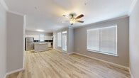 Located at 10498 Fountain Lake Drive in Stafford, TX, this single-floor, 2-bedroom, 3-bathroom home offers a well-designed layout with a clean, modern aesthetic. The open-concept living and kitchen area serves as the heart of the home, featuring light wood-look flooring, crown molding, and a ceiling fan with light fixture. Large windows fitted with white blinds allow natural light to fill the space, enhancing its bright and airy feel.

The kitchen is well-appointed with white cabinetry, a teal subway tile backsplash, stone-look countertops, a curved center island, and a full suite of stainless steel appliances including a refrigerator, range, microwave, and dishwasher. The layout provides ample counter and storage space for everyday functionality.

Both bedrooms are carpeted and include ceiling fans and windows with natural light. The primary bedroom is a comfortable size and connects to its own bathroom. Each bathroom features light wood flooring, white vanity cabinetry, and generous counter space with large mirrors.

Additional spaces include a hallway, two closets, and an entrance area that contribute to practical everyday living. The neutral gray and white color palette throughout the home creates a cohesive, move-in-ready environment suited for a variety of lifestyles.