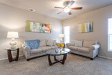 Located at 6720 28th St in Lubbock, TX, this single-story residence offers a well-designed, open-concept floor plan that maximizes functionality and comfort throughout. The living area is warm and inviting, featuring plush carpeting, a ceiling fan, and a large window that allows natural light to fill the space. Neutral-toned walls provide a versatile backdrop, complemented by colorful abstract wall art that adds a contemporary touch.

The kitchen is a standout feature, showcasing rich dark cabinetry, granite-style countertops, wood-look flooring, and a full suite of stainless steel appliances including a refrigerator, range, and over-the-range microwave. A breakfast bar provides additional seating and connects the kitchen seamlessly to the living space.

Adjacent to the living area, a dedicated dining space accommodates a round table and chairs, with a window that brings in additional natural light, making it an ideal setting for everyday meals.

The bedroom is generously sized with soft carpeting, a ceiling fan, and a window offering exterior views. The bathroom features dark wood cabinetry, a granite-topped vanity, wood-look flooring, and a tub-shower combination, providing a clean and cohesive aesthetic throughout the home.