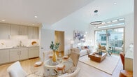 This thoughtfully designed single-floor residence combines contemporary architecture with a warm, inviting palette to create a cohesive and functional living environment. Light hardwood flooring flows throughout, tying together each space seamlessly.

The open-concept living and dining area serves as the heart of the home, highlighted by soaring vaulted ceilings, recessed lighting, and a striking circular pendant fixture. A wall of floor-to-ceiling sliding glass doors opens to a private outdoor balcony, flooding the space with natural light and offering views of the surrounding exterior. The dining area accommodates a glass-top round table, while the living room provides ample space for relaxed seating.

The kitchen features flat-front cabinetry in a soft grey tone, white countertops, stainless steel appliances including a gas range, and under-cabinet lighting that creates a clean, efficient workspace.

Two well-proportioned bedrooms offer comfortable retreats, each with light-toned walls, recessed lighting, and generous built-in closet storage. The primary bedroom includes sliding panel doors for closet access and connects conveniently to adjoining spaces.

Two bathrooms round out the layout. One features a frameless glass walk-in shower with built-in niches and terrazzo-style flooring, while the second offers a full soaking tub and shower combination with a sleek vanity and round mirror.