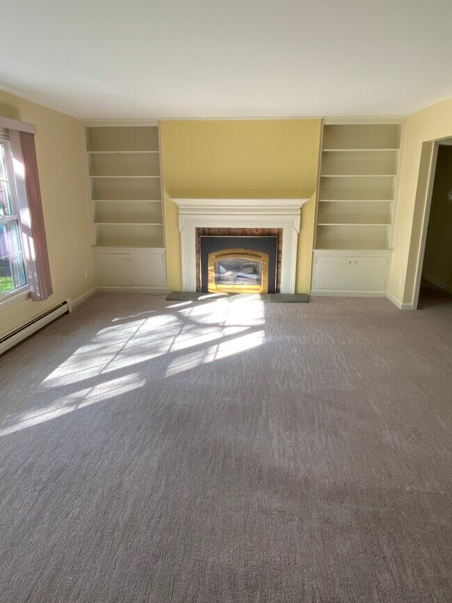 Living room with fireplace and picture window overlooking large sycamores - 6 Woodbrook Dr