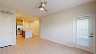 Located at 1105 Grassy Lake Dr in Davenport, FL, this well-appointed single-floor residence offers a thoughtfully designed open-concept layout. Light wood-style flooring runs throughout, creating a clean and cohesive aesthetic across every room.

The kitchen is a standout feature, showcasing flat-front cabinetry in a warm taupe finish, a full suite of stainless steel appliances — including a gas range, built-in microwave, and French door refrigerator — white subway tile backsplash, and a large central island with a white quartz countertop and undermount sink, providing both prep space and a natural gathering point.

The kitchen flows seamlessly into the open living area, which is brightened by natural light from windows and a glass-paneled door that leads to a private outdoor area. A ceiling fan with integrated lighting serves both the living space and the bedroom.

The bedroom is a comfortable, well-proportioned room with a window offering views of the surrounding Florida landscape. It provides direct access to a walk-in closet equipped with wire shelving systems for organized storage.

The bathroom features a warm wood-toned vanity with a white countertop, a large mirror, and a soaking tub with marble-look tile surround, lending a clean, modern feel. Light wood flooring continues throughout, maintaining the unit's consistent design language.