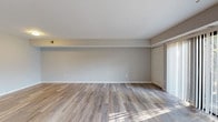 This single-floor residence offers a thoughtfully designed layout that balances open living areas with private, comfortable spaces. The main living area is bright and generously sized, featuring light-toned wood-style flooring and neutral gray walls that create a clean, modern aesthetic. Large sliding glass doors with vertical blinds flood the space with natural light and open to a private balcony overlooking lush greenery, enhancing the sense of openness throughout.

The kitchen is outfitted with rich, dark espresso cabinetry, speckled countertops, and stainless steel appliances including an electric range and over-the-range microwave, offering both style and practicality. The kitchen connects seamlessly to the main living space, making it ideal for everyday living.

The bedrooms are carpeted in a warm, neutral tone and feature bright windows and generous closet space, including a bifold-door reach-in closet in one room and a walk-in closet adjacent to one of the bathrooms. Two bathrooms serve the residence — one featuring a glass-enclosed walk-in shower with white tile surround, and the other offering a full soaking tub with tile surround and chrome fixtures. A dedicated utility area houses a high-efficiency water heater and in-unit washer, adding everyday convenience. The space is clean, updated, and move-in ready.