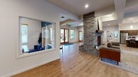 Located at 6655 Britton Pkwy NE in Lacey, Washington, this single-floor community amenity space offers a thoughtfully designed layout that balances comfort, functionality, and modern aesthetics across a generously sized footprint.

The main lounge area serves as the heart of the space, anchored by a striking floor-to-ceiling stacked stone fireplace with a wood mantel that creates a warm and inviting focal point. Light hardwood flooring flows throughout, complementing the clean white walls and recessed lighting. Comfortable seating and a dedicated computer workstation area make the lounge well-suited for both relaxation and productivity. Natural light pours in through multiple windows dressed with wood-trimmed blinds.

The kitchen is outfitted with rich dark wood cabinetry, light quartz countertops, and stainless steel appliances including a full refrigerator, range, microwave, and dishwasher. A central island with bar seating adds additional workspace and a casual dining option, while pendant lighting adds a refined touch overhead.

The fitness center is generously equipped with cardio machines including treadmills, ellipticals, and a stationary bike, alongside a cable weight machine, free weights, kettlebells, resistance equipment, and wall-to-wall mirrors that enhance the sense of space. Windows provide natural light and views of the surrounding greenery, creating an energizing workout environment.