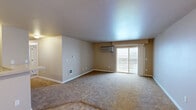 Located in Airway Heights, Washington, this well-appointed 3-bedroom, 2-bathroom residence offers a comfortable and functional layout across a single floor. The open-concept living, dining, and kitchen area serves as the heart of the home, featuring neutral-toned walls, plush carpeting, and tile flooring that transitions seamlessly between spaces. A wall-mounted HVAC unit keeps the living area climate-controlled, while sliding glass doors lead to a private balcony, filling the room with natural light and offering outdoor views.

The kitchen is equipped with warm wood cabinetry, black appliances including a range, microwave, and refrigerator, a breakfast bar, a pantry, and track lighting overhead. The generous primary bedroom includes a closet and baseboard heating, while the two additional bedrooms are carpeted and feature natural light from windows. Each bedroom offers convenient closet storage, with four closets distributed throughout the unit.

The two bathrooms are finished with tile flooring and warm neutral tones. One features a full tub-shower combination, while the other includes a wood-toned vanity with an integrated sink and mirror. Two hallways connect the spaces efficiently, completing this practical and well-organized home.