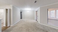 Located at 6300 Milgen Rd in Columbus, GA, this single-floor, one-bedroom, one-bathroom home offers a practical and comfortable layout with neutral tones throughout. The combined kitchen and living area serves as the heart of the home. The living room features plush carpeting, crown molding, a classic fireplace framed by a white mantel, and a built-in shelving unit — ideal for display or storage. A chandelier adds an elegant touch to the space, which also includes sliding glass doors that bring in natural light. The kitchen is well-appointed with white cabinetry, light stone-look countertops, wood-look flooring, and a full suite of stainless steel appliances including a refrigerator, range, and microwave. A dedicated laundry area and walk-in closet with wire shelving add everyday convenience. The spacious bedroom is carpeted and includes a ceiling fan with light and a window for natural light. The bathroom offers a full tub-shower combination with clean white surrounds and chrome fixtures. With a textured ceiling, crisp white trim, and a cohesive neutral palette, this home presents a move-in-ready, functional living space.
