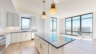 Located in the heart of Atlanta's Midtown neighborhood, this thoughtfully designed residence offers a seamless blend of modern aesthetics and functional living. The open-concept kitchen serves as a central showpiece, featuring crisp white shaker cabinetry adorned with brushed gold hardware, dark quartz countertops, a spacious center island, stainless steel appliances, and elegant pendant lighting with antique brass accents. Large windows flood the kitchen and adjacent living areas with abundant natural light while framing impressive views of the Atlanta skyline.

The living spaces are anchored by light-toned hardwood flooring throughout, complemented by clean white walls that enhance the bright, airy atmosphere. Floor-to-ceiling windows in the bedrooms deliver breathtaking panoramic views of the city, with landmarks such as Bank of America Plaza clearly visible.

The bathroom is finished with distinctive navy blue cabinetry, gold hardware, marble-style tile flooring, white subway tile, and a soaking tub with shower combo, offering a refined and cohesive design. An in-unit laundry closet houses a full-size GE washer and dryer with overhead shelving for added convenience. The overall ambiance is contemporary and polished, with high-end finishes and sweeping urban vistas defining the character of the space.