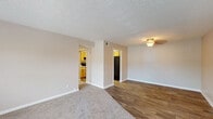 Located at 221 Olde English Ct in Louisville, Kentucky, this single-floor residence offers a practical and comfortable layout designed for everyday living. The main living area features a combination of plush carpeting and wood-look vinyl flooring, creating a clear distinction between relaxing and high-traffic zones. A textured ceiling and a ceiling-mounted light fixture add character to the space, while large windows along the front wall allow natural light to fill the room. The living area connects openly to the kitchen and dining spaces, promoting a functional flow throughout. The kitchen is outfitted with warm honey-toned wood cabinetry, light countertops, black appliances including a range and refrigerator, and an under-cabinet range hood — providing ample storage and workspace. The bedrooms are carpeted for comfort, each featuring neutral walls and windows with blinds for natural light and privacy. At least one bedroom includes a closet with bifold doors for organized storage. The unit includes two bathrooms: one features a wood-vanity with a framed mirror and a shower-tub combination, while the second offers similar finishes with a tiled shower surround. Overall, the space presents a clean, neutral palette throughout, making it a versatile and move-in ready residence.