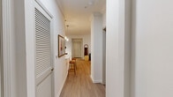 Located at 100 Grayson Place in Decatur, GA, this single-floor, 2-bedroom, 2-bathroom residence offers a thoughtfully designed layout that balances comfort and contemporary style. Light-toned hardwood-style flooring flows throughout, complemented by crisp white walls and crown molding details that lend an air of polish to each room.

The galley-style kitchen is a standout feature, showcasing striking navy lower cabinetry paired with white upper cabinets, quartz countertops, stainless steel appliances, a deep undermount sink, and pendant lighting — with a direct view into the dedicated laundry room housing full-size washer and dryer units. The adjacent dining area makes a bold statement with a dramatic navy botanical wallpaper featuring a tiger motif.

The spacious primary bedroom accommodates a king-size layout and includes a ceiling fan and access to a generously sized walk-in closet with multi-level wire shelving. The bathrooms feature navy vanity cabinetry with white countertops and tiled tub-shower combinations. The living room benefits from natural light through large windows, while the hallways connect the space efficiently. Two closets and dedicated laundry add meaningful storage and convenience throughout this well-rounded Decatur residence.