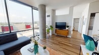 Located in Chicago's vibrant River West neighborhood, this contemporary residence at 840 W Blackhawk St offers a thoughtfully designed open-concept layout bathed in natural light. The living area is a standout, anchored by dramatic floor-to-ceiling windows that frame sweeping city views and highlight a striking exposed concrete column — a nod to the building's modern industrial aesthetic. Warm hardwood flooring flows throughout, complementing the bright white walls and creating a cohesive, inviting atmosphere.

The kitchen is outfitted with rich dark cabinetry, granite countertops, stainless steel appliances including a dishwasher, and ample storage — making it as functional as it is stylish. A dedicated dining area with space for a round table sits adjacent, ideal for everyday meals or entertaining.

The bathroom features tile flooring, a granite-topped vanity with dark cabinetry, a tub-shower combination with elegant marble-patterned tile surround, and well-lit vanity mirror. Throughout the residence, clean lines and a neutral palette provide a versatile backdrop. The abundance of natural light, city views, and thoughtful architectural details make this a distinctive urban retreat in one of Chicago's most dynamic neighborhoods.