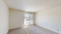 Located at 5125 47th Ave in Sacramento, CA, this one-bedroom, one-bathroom unit offers a practical and well-organized single-floor layout. The living room is a bright, open space featuring plush wall-to-wall carpeting, neutral cream-toned walls, and a large window fitted with vertical blinds that allow generous natural light and outdoor views of surrounding greenery. The kitchen is efficiently designed with white cabinetry, laminate countertops, a stainless sink, and white appliances including a dishwasher and refrigerator, all set on durable wood-look vinyl flooring. The bedroom offers a comfortable footprint with soft carpeting, neutral walls, and a window that brings in additional natural light. A dedicated closet provides convenient storage within the unit. The bathroom features a full-size tub and shower combination with clean white surrounds. Throughout the unit, a consistent neutral color palette and textured ceilings contribute to a clean, understated aesthetic. The layout flows efficiently, making practical use of the available space across each room.