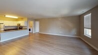 Located at 222 Norristown Rd in Warminster, PA, this single-floor residence offers a well-designed, open-concept layout finished with consistent light hardwood flooring throughout the main living areas. The spacious living and dining area flows seamlessly into the kitchen, which is equipped with stainless steel appliances including a refrigerator, range, and microwave, complemented by rich dark cabinetry, granite countertops, and a peninsula with additional seating space. An in-unit washer is conveniently accessible from the main living area. The primary bedroom is generously sized, bathed in natural light from multiple windows with outdoor views, and connects directly to a well-appointed en-suite bathroom featuring a dual-sink vanity with granite countertops, dark cabinetry, a large mirror with overhead lighting, and tile flooring. A second bedroom also benefits from natural light through a large window with outdoor views. A walk-in closet with wire shelving provides ample storage. The bathroom hallway offers additional privacy with multiple doors providing access to adjoining spaces. Neutral wall tones, white trim, and clean architectural lines contribute to a bright, modern, and cohesive ambiance throughout.