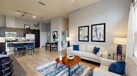 Located at 940 W Canton Ave in Winter Park, FL, this well-appointed 2-bedroom, 3-bathroom residence offers a thoughtfully designed single-floor layout. The open-concept living and dining area immediately impresses with soaring ceilings, light wood-style flooring, and an abundance of natural light streaming through large windows. A ceiling fan adds comfort, while the generous wall space accommodates wall-mounted media and decorative artwork.

The kitchen is outfitted with rich dark wood cabinetry, granite countertops, a classic subway tile backsplash, stainless steel appliances including a dishwasher, and ample storage throughout. A dedicated dining area sits adjacent, making entertaining seamless.

The primary bedroom features plush carpet, elevated ceilings, natural light from transom-style windows, and direct access to an en-suite bathroom. The second bedroom is equally well-sized with its own bathroom access. The three bathrooms are finished with granite vanities, dark wood cabinetry, tile flooring, and include both a glass-enclosed shower and a full soaking tub option.

A dedicated laundry room houses a full-size washer and dryer with built-in shelving for added storage. Two closets provide practical organization throughout. The overall aesthetic is clean, modern, and cohesive, with soft gray walls and warm wood tones creating an inviting atmosphere.
