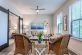 Located on Rifle Range Road in the desirable Mount Pleasant, South Carolina community, this single-floor residence offers a well-appointed and thoughtfully designed living space. The open-concept layout connects the kitchen and living areas seamlessly, creating a functional and inviting atmosphere throughout.

The kitchen is outfitted with crisp white shaker-style cabinetry extending to the ceiling for generous storage, light quartz countertops, and a full suite of stainless steel appliances including a range, over-the-range microwave, dishwasher, and refrigerator. Warm hardwood-style flooring runs through the kitchen and main living areas, adding character and continuity.

The living room is bright and comfortable, featuring multiple windows dressed with horizontal blinds that allow natural light to filter in while providing views of the surrounding greenery. A ceiling fan overhead adds both function and a relaxed coastal ambiance, complementing the neutral wall tones throughout.

The bedroom is a calm retreat, finished with plush carpeting and softly lit by warm bedside lighting. It is served by a spacious walk-in closet equipped with wire shelving and hanging rods, offering practical and organized storage.

The bathroom is clean and modern, with large-format tile flooring, a tub-shower combination with a crisp white curtain, and a white vanity with ample counter space. The overall aesthetic of the residence blends coastal charm with contemporary finishes.