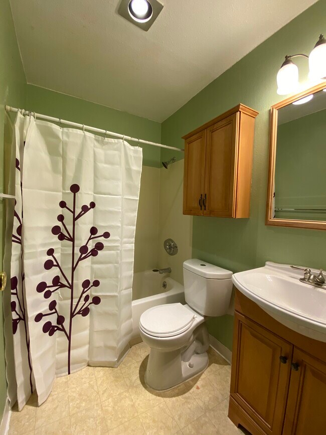 bathroom with tiled surround and cabinets, low flow toilet, tub and shower - 3393 Madison Ave