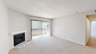Located at 43032 30th St W in Lancaster, CA, this well-appointed 2-bedroom, 2-bathroom single-floor residence offers a thoughtfully designed layout across a comfortable footprint. The living room serves as the heart of the home, featuring plush carpeting, a classic fireplace with a clean white mantle, and a full-width sliding glass door that opens to a private balcony and allows abundant natural light to fill the space. A dedicated dining area connects seamlessly to the galley-style kitchen, which is outfitted with crisp white cabinetry, light wood-look flooring, quartz countertops, and a full suite of stainless steel appliances including a gas range, microwave, refrigerator, and dishwasher. The spacious primary bedroom includes a walk-in closet with built-in shelving and direct access to a hallway. Both bathrooms feature clean, white tub-shower combos with chrome fixtures. The second bedroom is carpeted and benefits from a window with natural light. Additional highlights include a dedicated laundry area, a second closet, and a connecting hallway that ties the layout together efficiently. Textured ceilings and neutral tones throughout lend a consistent, move-in-ready aesthetic.