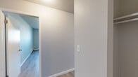 Located at 115 S Academy Blvd in Colorado Springs, CO, this 2-bedroom, 1-bathroom unit offers a well-organized single-floor layout designed for comfortable everyday living. Light wood-look flooring runs consistently throughout the space, creating a clean, cohesive aesthetic enhanced by neutral gray and beige wall tones.

The kitchen is efficiently designed with updated gray shaker-style cabinetry, light marbled countertops, and white appliances including a refrigerator, electric range, and dishwasher. A peninsula provides additional prep space and separates the kitchen from the adjacent living area. The living room is bright and welcoming, featuring a sliding glass door with vertical blinds that opens to an outdoor area and allows natural light to fill the room.

Both bedrooms are well-proportioned, with the spacious primary bedroom offering a comfortable retreat. Each bedroom features windows with vertical blinds and baseboard heating. A dedicated closet provides practical storage.

The bathroom is finished with a full tub and shower combination accented by striking marble-patterned wall surrounds and brushed nickel fixtures, adding a refined touch to the space. Textured ceilings are present throughout, lending a classic residential character to the overall design.