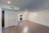 Located at 7511 N 1st St in Fresno, California, this single-story home offers three bedrooms and three bathrooms across a well-organized floor plan. The living room serves as a welcoming centerpiece, featuring rich wood-style laminate flooring, a tile-surround fireplace, and a large window that fills the space with natural light and outdoor views. A ceiling fan adds comfort and a textured ceiling carries throughout the home.

The kitchen is efficiently designed with a U-shaped layout anchored by a peninsula with a double stainless steel sink. Dark wood cabinetry provides ample storage, complemented by light countertops and a stainless steel range. Wood-style flooring continues here, connecting seamlessly with the adjacent living areas.

The bedrooms offer a contrast in flooring, featuring plush carpet for added comfort. The primary bedroom is generously sized and includes an en-suite bathroom with an extended double-sink vanity, wood cabinetry, and a large mirror with bright overhead lighting. Additional bedrooms include sliding closet doors and windows for natural light. Secondary bathrooms are equipped with shower-tub combos, single-sink vanities, and wood cabinetry. Ceiling fans are present in multiple rooms throughout the home, enhancing everyday livability.