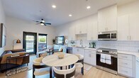 Located in Gilbert, AZ, this thoughtfully designed one-bedroom, one-bathroom unit offers a clean, contemporary aesthetic throughout. The open-concept kitchen and living area serves as the heart of the home, featuring crisp white cabinetry, a classic subway tile backsplash, light hardwood-style flooring, and a full suite of stainless steel appliances including a refrigerator, range, microwave, and dishwasher. Recessed lighting and a ceiling fan enhance the bright, airy atmosphere, while large windows invite abundant natural light and outdoor views. The kitchen flows seamlessly into the living and dining area, making the layout feel open and functional. The bedroom is a comfortable retreat, carpeted for warmth and outfitted with large black-framed windows that frame views of the surrounding Gilbert streetscape. The full bathroom is clean and minimalist, finished with light tile flooring and a simple, functional layout. A dedicated walk-in closet with built-in shelving and hanging rods provides generous storage. The unit's modern design, neutral color palette, and efficient use of space make it a well-appointed home in the heart of Gilbert.