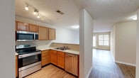 Located at 100 Chamberlain Dr in Asheville, NC, this single-floor, 3-bedroom, 2-bathroom home offers a practical and comfortable layout with wood-style flooring throughout. The open-concept kitchen and living area form the heart of the home, featuring warm honey-toned cabinetry, light countertops, and a full suite of stainless steel appliances including a refrigerator, electric range, microwave, and dishwasher. A peninsula counter provides a natural divide between the kitchen and living space. The spacious living room is filled with natural light from large windows and a glass patio door that opens to a private outdoor patio. Each of the three bedrooms offers a ceiling fan with light fixture, ample closet space with bifold doors, and neutral wall tones that complement the light hardwood-style floors. The generously sized primary bedroom provides a comfortable retreat. Both bathrooms are finished with warm wood vanities and full tub/shower combinations. A dedicated utility room and hallway add functional storage and flow to the layout. The textured ceilings and neutral color palette throughout create a clean, cohesive aesthetic well-suited to a variety of interior styles.