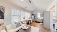 Located at 201 Grafton Way in Myrtle Beach, South Carolina, this single-story residence offers a well-designed, open layout filled with natural light throughout. The entry foyer welcomes guests with vaulted ceilings that carry through into the living area, where large windows fitted with white blinds allow abundant daylight to brighten the neutral-toned interior. Wood-look flooring runs consistently throughout the main living spaces, lending warmth and visual continuity.

The living area transitions seamlessly into a dining space and kitchen, making the open-concept layout ideal for both daily living and entertaining. The kitchen is equipped with stainless steel appliances—including a refrigerator, dishwasher, electric range, and over-the-range microwave—complemented by gray shaker-style cabinetry, white countertops, and a subway tile backsplash. A casual dining area with ample window exposure sits adjacent to the kitchen.

The bedrooms offer comfortable, well-lit retreats, each with large windows and ceiling fans. The primary bedroom connects to a private en-suite bathroom featuring a walk-in glass shower, a single-sink vanity with white countertop, and gray cabinetry. An additional full bathroom serves the remaining bedrooms. Throughout, the home maintains a clean, contemporary aesthetic with a light, airy ambiance.