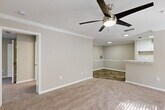 Located at 950 Lake Ridge Pkwy in Riverdale, GA, this well-appointed one-bedroom, one-bathroom residence offers a thoughtfully designed single-floor layout. The open-concept living and kitchen area forms the heart of the home, where wood-look flooring flows seamlessly from the kitchen into the main corridor, transitioning to plush carpeting in the living space. The kitchen features white cabinetry, granite-style countertops, a breakfast bar peninsula, and a full suite of appliances, all illuminated by a skylight-style overhead fixture. Crown molding and a ceiling fan with light kit add a polished touch to the living room, which benefits from natural light streaming in through a sliding glass door that opens to an outdoor balcony. The spacious bedroom offers generous proportions, soft carpet underfoot, a ceiling fan, and a large walk-in closet with built-in shelving. The bathroom continues the refined aesthetic with a wide granite-topped vanity, white cabinetry, a large mirror, and wood-look flooring. A dedicated laundry room with an in-unit full-size washer and dryer completes this functional and comfortable home.