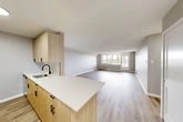 Located at 770 James St in Syracuse, NY, this 1-bedroom, 1-bathroom unit offers a thoughtfully designed layout across a single floor. Light-toned luxury vinyl plank flooring flows throughout, complementing the neutral gray walls and crisp white trim that create a clean, modern aesthetic.

The open-concept living and dining area is generously proportioned, bathed in natural light from a wide bank of windows that frame outdoor views of the surrounding landscape. A door provides direct access to a private patio, extending the living space outdoors.

The kitchen is efficiently designed with light wood cabinetry accented by matte black hardware, a white quartz countertop, subway tile backsplash, and stainless steel appliances including a gas range, microwave, and refrigerator. A peninsula with an integrated sink adds prep space and a casual dining option.

The spacious primary bedroom features the same warm flooring, soft neutral walls, and access to multiple closets, offering ample storage. The bathroom is finished with striking large-format marble-look tile in both light and dark tones surrounding a soaking tub, delivering a refined, spa-like feel. Three closets throughout the unit provide exceptional storage for a residence of this size.