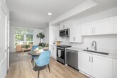 Located at 1999 W 3rd St in Los Angeles, CA, this thoughtfully designed one-bedroom, one-bathroom unit maximizes its compact footprint with an efficient, open-concept layout. Light wood-tone flooring runs throughout, tying the living spaces together seamlessly.

The kitchen is a standout feature, outfitted with crisp white shaker cabinetry, dark countertops, and a full suite of stainless steel appliances including a gas range, over-the-range microwave, dishwasher, and refrigerator. Recessed lighting and a raised ceiling detail above the kitchen add visual interest and a sense of height. A cozy dining area sits adjacent, offering space for a small table and chairs.

The living room benefits from large windows that invite abundant natural light and frame greenery from the surrounding streetscape, creating an airy, welcoming atmosphere. The bedroom is bright and serene, featuring its own large window with tree-lined views, light walls, and warm wood flooring — a peaceful retreat. Two closets provide practical storage throughout the unit.

The bathroom is clean and modern, featuring a white vanity with shaker-style cabinetry, a large mirror, and a shower-tub combination, all set against a light, neutral palette with wood-tone flooring. This well-appointed unit offers a comfortable, contemporary living experience in the heart of Los Angeles.