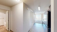 Located at 7410 S Hayford Rd in Spokane, WA, this one-bedroom, one-bathroom unit offers a compact and efficient single-floor layout designed to maximize comfort and functionality. The interior features a clean, neutral color palette with crisp white walls and light-toned finishes throughout, creating a bright and welcoming ambiance.

The kitchen is a standout feature, showcasing warm, rich-toned wood cabinetry extending to the upper walls for ample storage. It is equipped with black appliances including a range, microwave, refrigerator, and dishwasher, paired with light countertops and a double-basin sink. Wood-look flooring runs through the kitchen and hallway, lending a cohesive and easy-to-maintain aesthetic.

The hallway connects the kitchen seamlessly to the rest of the unit, with recessed overhead lighting ensuring the space remains well-lit. The bedroom offers a comfortable retreat with soft wall-to-wall carpeting, a window fitted with vertical blinds that invites natural light and outdoor views of the surrounding neighborhood.

The bathroom is clean and straightforward, featuring wood-look flooring, a full-size soaking tub with a shower rod, a toilet, and a towel bar. The overall design of this unit prioritizes practicality and livability, making it a functional home in a residential Spokane community.