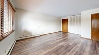 Located at 219 3rd Ave SW in Forest Lake, Minnesota, this two-bedroom, one-bathroom unit offers a practical and comfortable single-floor layout. The living room is bright and open, featuring hardwood-style flooring, a textured ceiling, and a wide window with wood-trimmed blinds that frames views of the surrounding neighborhood. Baseboard heating runs throughout the main living areas, ensuring consistent warmth during Minnesota winters.

The kitchen is efficiently designed with white cabinetry, granite-look countertops, stainless steel refrigerator and range, an under-cabinet range hood, and a ceiling fan with light. A window above the dining area brings in additional natural light, and a wall-mounted A/C unit provides seasonal climate control.

Both bedrooms are well-sized and carpeted for comfort. The primary bedroom benefits from dual windows with wood-trimmed blinds and a ceiling fan, while both rooms feature generous closet space — including large louvered bifold closet doors. The unit boasts an impressive six closets in total, offering exceptional storage throughout.

The full bathroom is cleanly finished with white tile surrounding the tub/shower combination, mosaic tile flooring, and classic fixtures. Hardwood-style flooring continues through the hallway, tying the space together cohesively.
