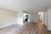 Located in New York Mills, NY, this well-appointed 2-bedroom, 1-bathroom single-floor residence offers a clean, modern aesthetic throughout. The open living area is anchored by warm hardwood-style flooring that extends seamlessly across the main living spaces, creating a cohesive and inviting atmosphere. Baseboard heating runs along the perimeter, ensuring comfort year-round. A second living area features a sliding glass door that fills the room with natural light and provides direct views of lush outdoor greenery, enhancing the connection to nature.

The kitchen is thoughtfully designed with white shaker cabinetry, marble-look countertops, a stainless steel sink, and a full suite of stainless steel appliances including a range, microwave, and dishwasher. A window above the sink brings in additional natural light.

The spacious primary bedroom includes direct access to a dedicated walk-in closet outfitted with wood shelving and double hanging rods for ample storage. The second bedroom is well-sized with a large window offering natural light and wooded views. The full bathroom features a tub/shower combo, a white vanity, and hardwood-style flooring. A hallway connects all rooms efficiently, completing this functional and attractively updated layout.