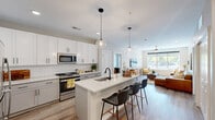 Located at 554 Lancaster Ave in Malvern, PA, this well-appointed 2-bedroom, 2-bathroom residence offers a thoughtfully designed single-floor layout. The open-concept kitchen is a standout feature, showcasing crisp white shaker cabinetry, a classic subway tile backsplash, stainless steel appliances, and a central island with a undermount sink and seating for multiple guests — all illuminated by stylish globe pendant lights. Light wood-look flooring flows seamlessly from the kitchen into the living room, which is bright and inviting, featuring a ceiling fan, large windows with natural light, and comfortable proportions ideal for entertaining. The spacious primary bedroom offers plush carpeting, a ceiling fan, and generous closet storage, while the en-suite bathroom includes a dual-sink vanity with white quartz countertops, gray shaker cabinetry, and matte black fixtures. The second bathroom features a tub-shower combo and matching quartz finishes. The second bedroom mirrors the primary in comfort and style. Three closets, a dedicated laundry area, and a utility room provide excellent storage and functionality throughout. The neutral color palette and modern finishes give the space a clean, contemporary feel.