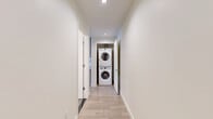 Located in the heart of Downtown Los Angeles, this modern 1-bedroom, 1-bathroom residence at 1133 S Hope St offers a well-designed layout with contemporary finishes throughout. Light wood-tone flooring runs continuously across the space, complementing the clean, neutral color palette.

The open-concept kitchen and living area serves as the central hub of the home. The kitchen is outfitted with sleek gray flat-front cabinetry extending to the ceiling, a light-blue subway tile backsplash, white quartz countertops, and a full suite of stainless steel appliances including a gas range, built-in microwave, dishwasher, and French door refrigerator. In-unit washer and dryer are also included.

The living area benefits from floor-to-ceiling windows and a glass door that frame sweeping urban views of the Downtown LA skyline, flooding the space with natural light. The bedroom is generously proportioned, featuring a large walk-in closet and an expansive window with city views. The bathroom is finished with large-format gray floor tiles, a full soaking tub with shower combination, and crisp white wall surrounds. A connecting hallway ties all areas together efficiently, maximizing the functional use of the overall footprint.