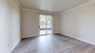 Located at 3401 Savannah Ln in West Sacramento, CA, this single-floor residence offers three bedrooms and three full bathrooms in a well-organized layout. Light wood-style flooring runs throughout, lending a clean, cohesive feel to every room. The living room is bright and open, with crown molding accents and a sliding glass door that leads to a private balcony overlooking lush greenery — an inviting spot that brings natural light and outdoor views into the heart of the home. The kitchen features warm, rich wood cabinetry in a practical U-shaped layout with a breakfast bar peninsula that opens toward the living area. White appliances, including a refrigerator, electric range, and dishwasher, complement the neutral countertops. Each of the three bedrooms offers a comfortable footprint, with windows fitted with vertical blinds that provide both natural light and privacy. The primary bedroom includes built-in closet cabinetry with rich wood-toned doors. The three bathrooms are functional and consistent in style, each featuring wood-toned vanity cabinetry, light countertops, and tub-shower combinations. A connecting hallway ties the layout together efficiently. The overall palette of warm neutrals and wood tones creates a calm, livable ambiance throughout.